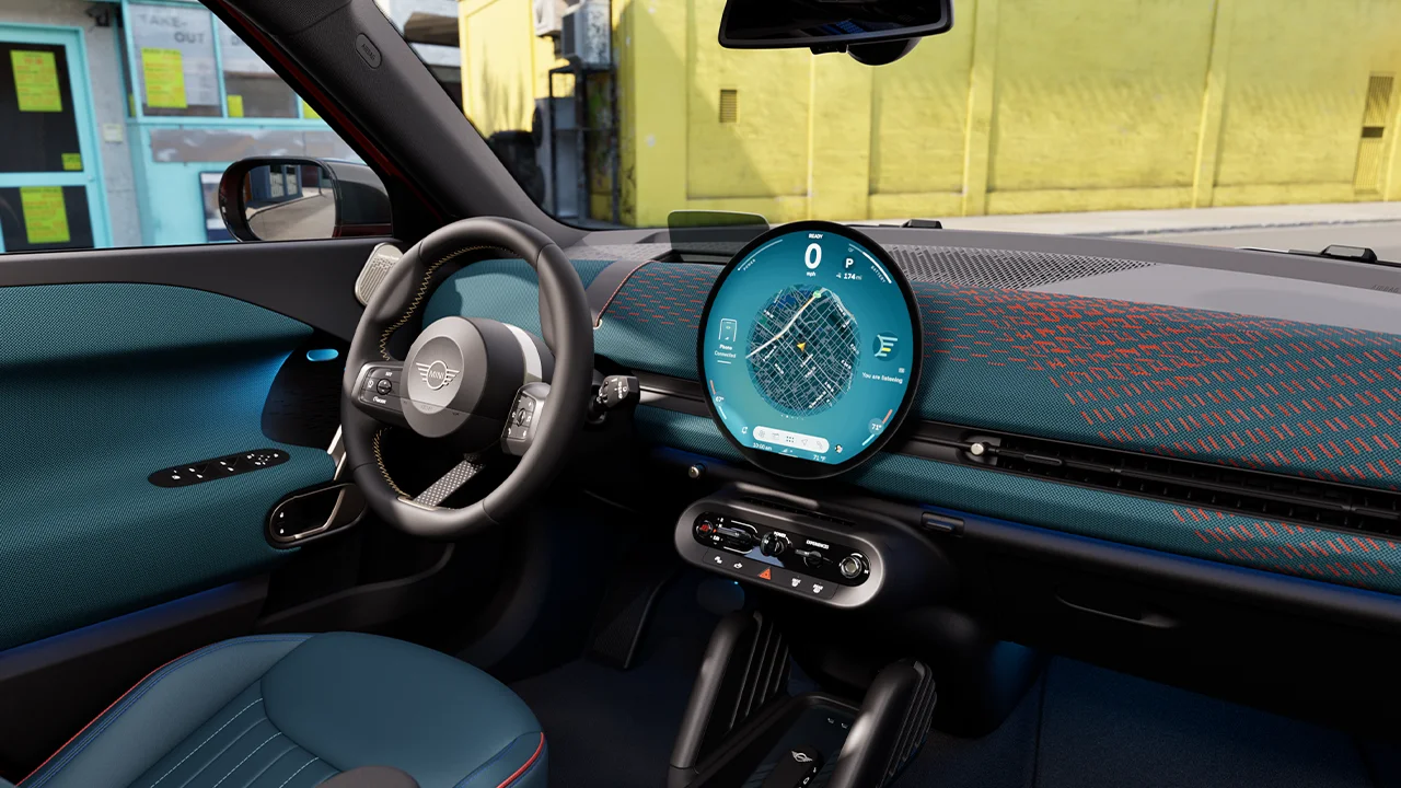 Panoramic view of the dashboard of the all-electric MINI Aceman with yellow wall in the background