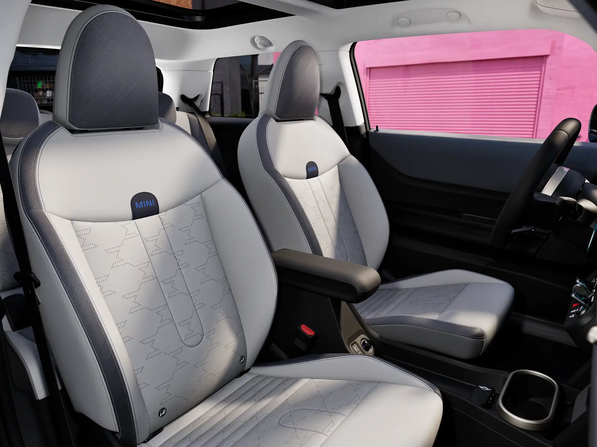 Interior perspective of the MINI Cooper is showing the dashboard, steering wheel, round display, panorama glassroof  and back of the frontseats.