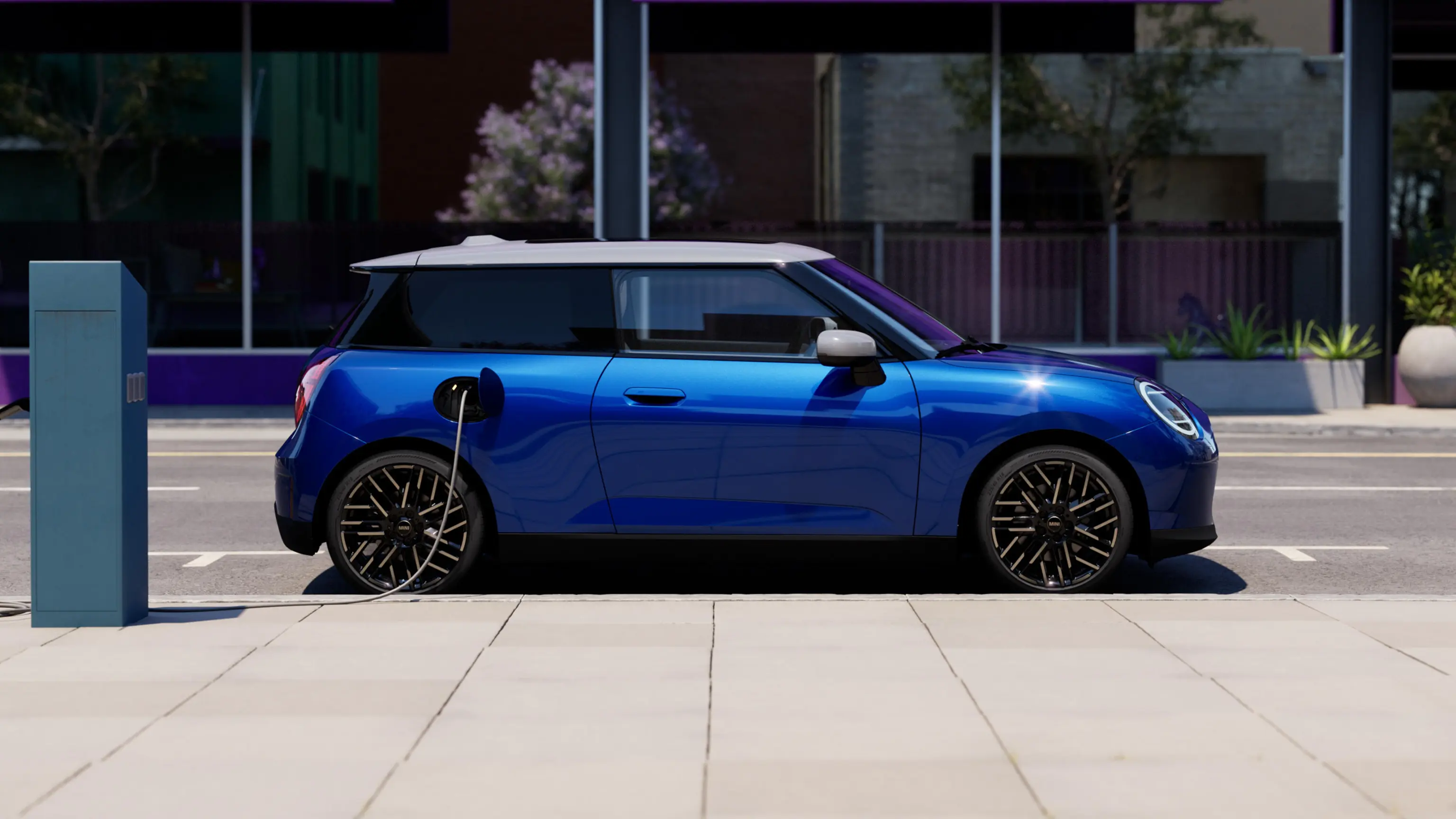Side View of Blazing Blue all-electric MINI Cooper parked on sidewalk beside a charging station