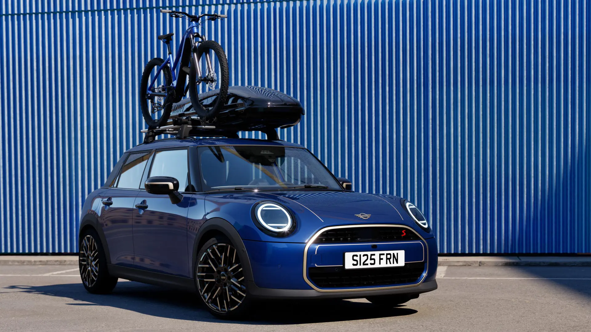 マウンテンバイクとミニルーフボックス320を搭載したミニルーフバイクラック付きのインディゴサンセットブルーのMINIエースマンの正面図。