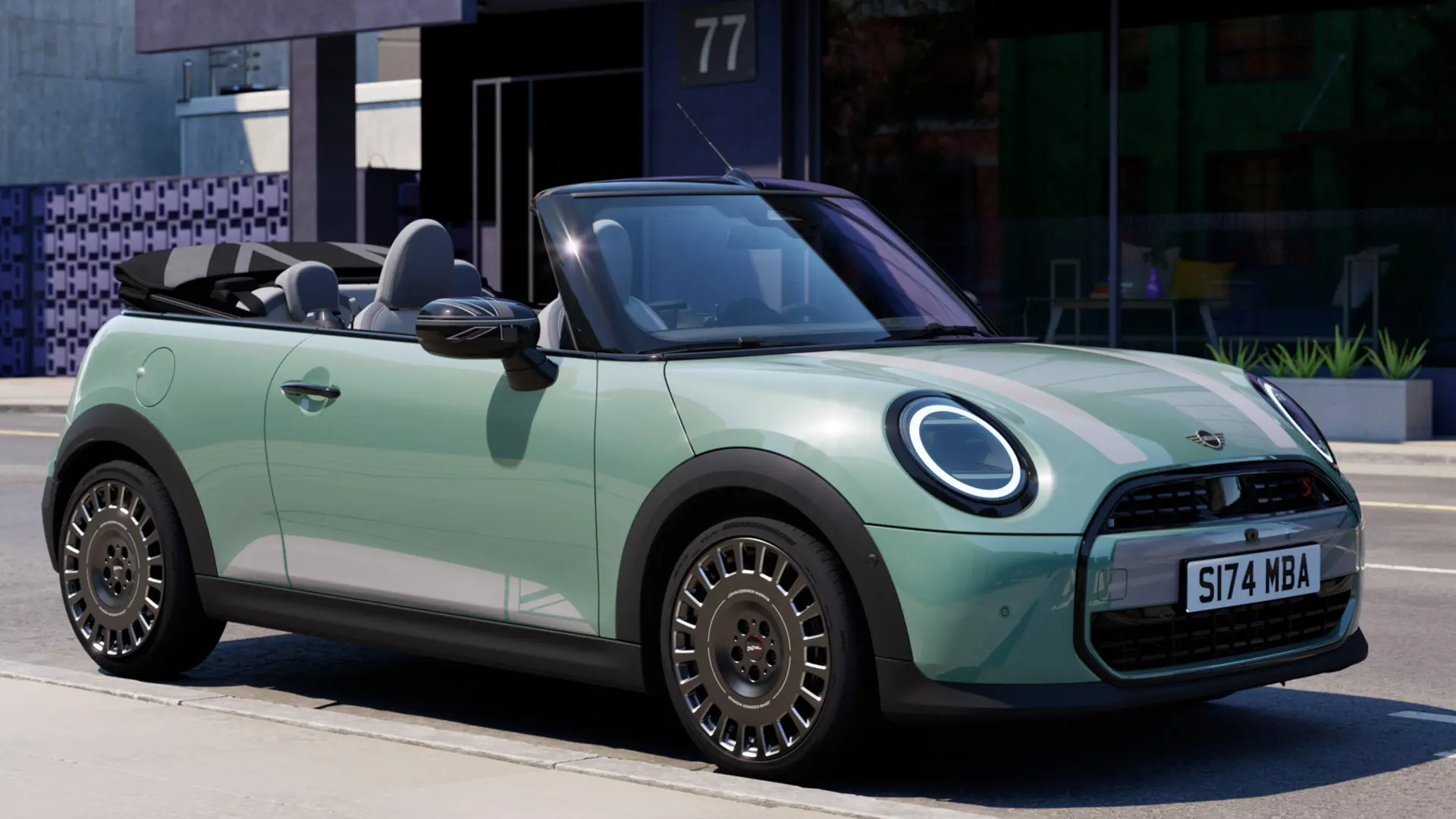 ホワイトのMINI ヘリテージ・ボンネット・デカールを装着した、オーシャン・ウェーブ・グリーンのMINIコンバーチブル（フロント／サイドビュー）。