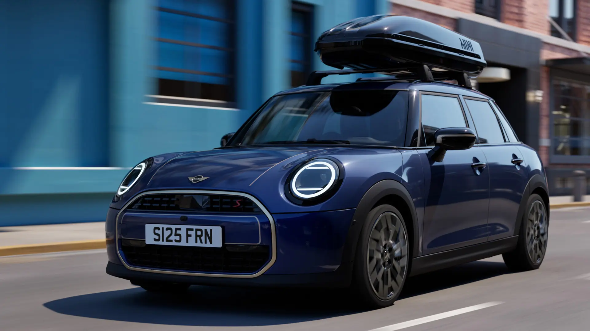 MINIルーフ・ラックとMINIルーフ・ボックス 320を装着した、インディゴ・サンセット・ブルーのMINIエースマン（フロント3/4ビュー）。