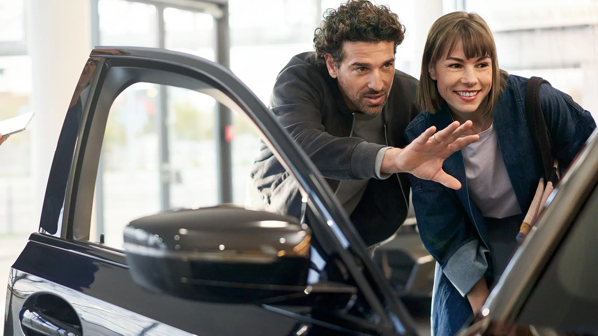 MINIはMINIディーラーセンター内にあり、コンサルタントがお客様にアドバイスし、インテリアの特徴を説明しています。