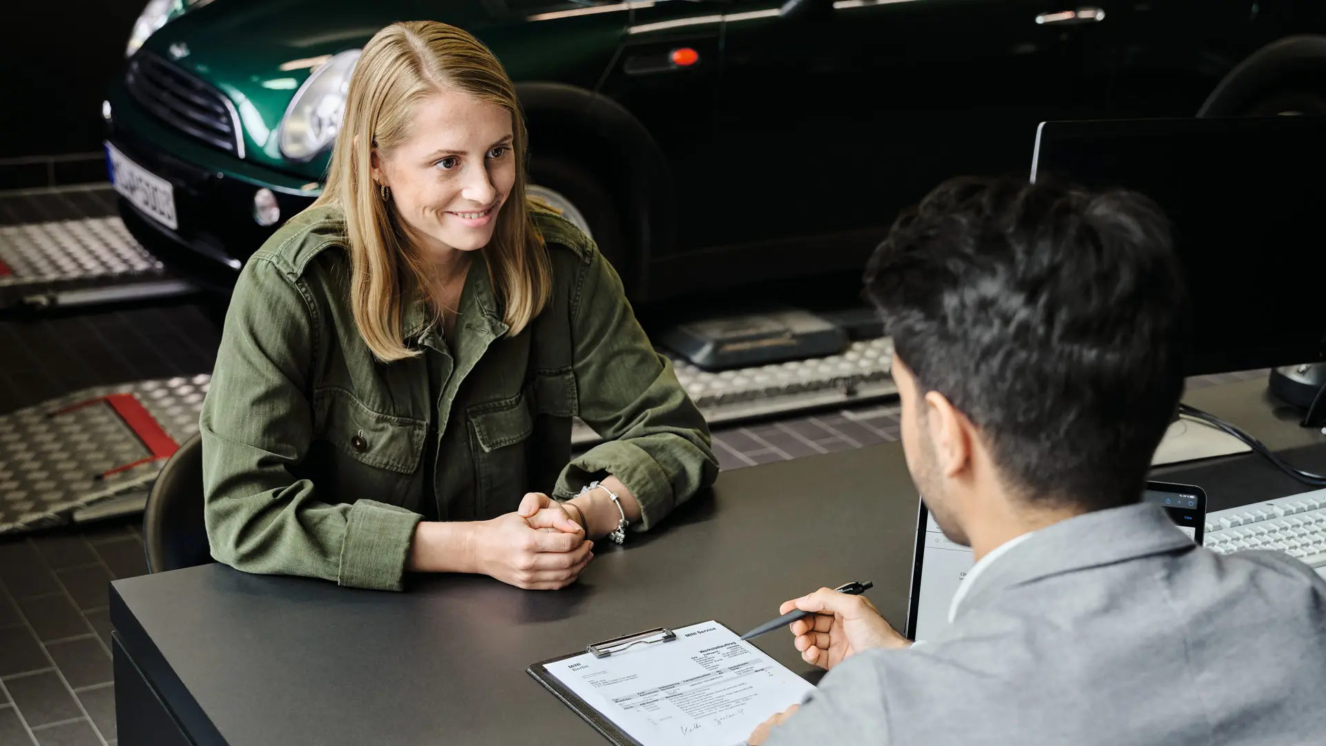 MINIセンターにはコンサルタントがいて、お客様にサービスオプションについてアドバイスしています。2人ともテーブルに座っています。