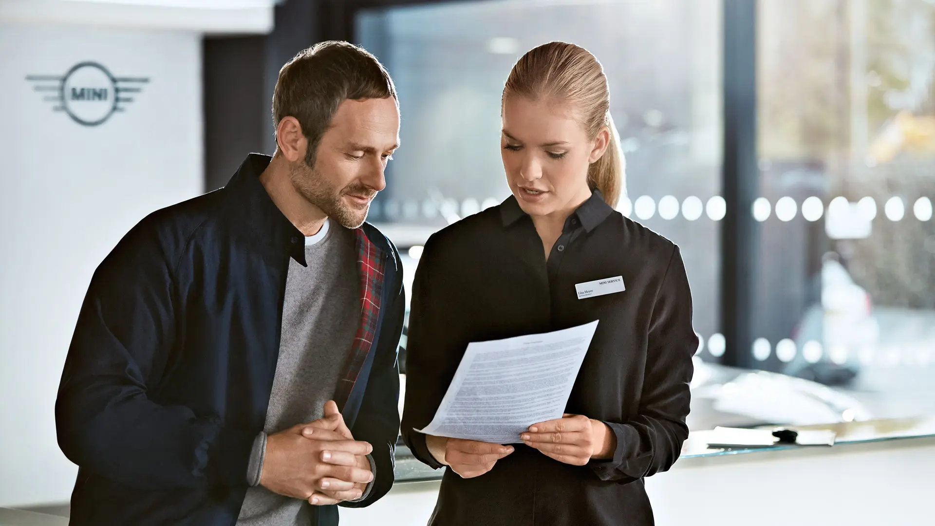 MINIのサービス担当者が、ディーラーでメンテナンス・プランについて説明しています。