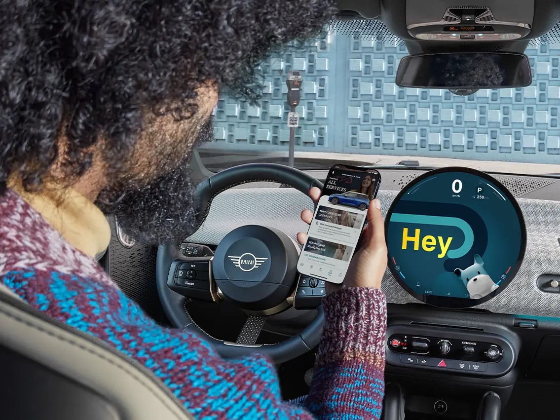 MINIの車内で携帯電話を見ている男性