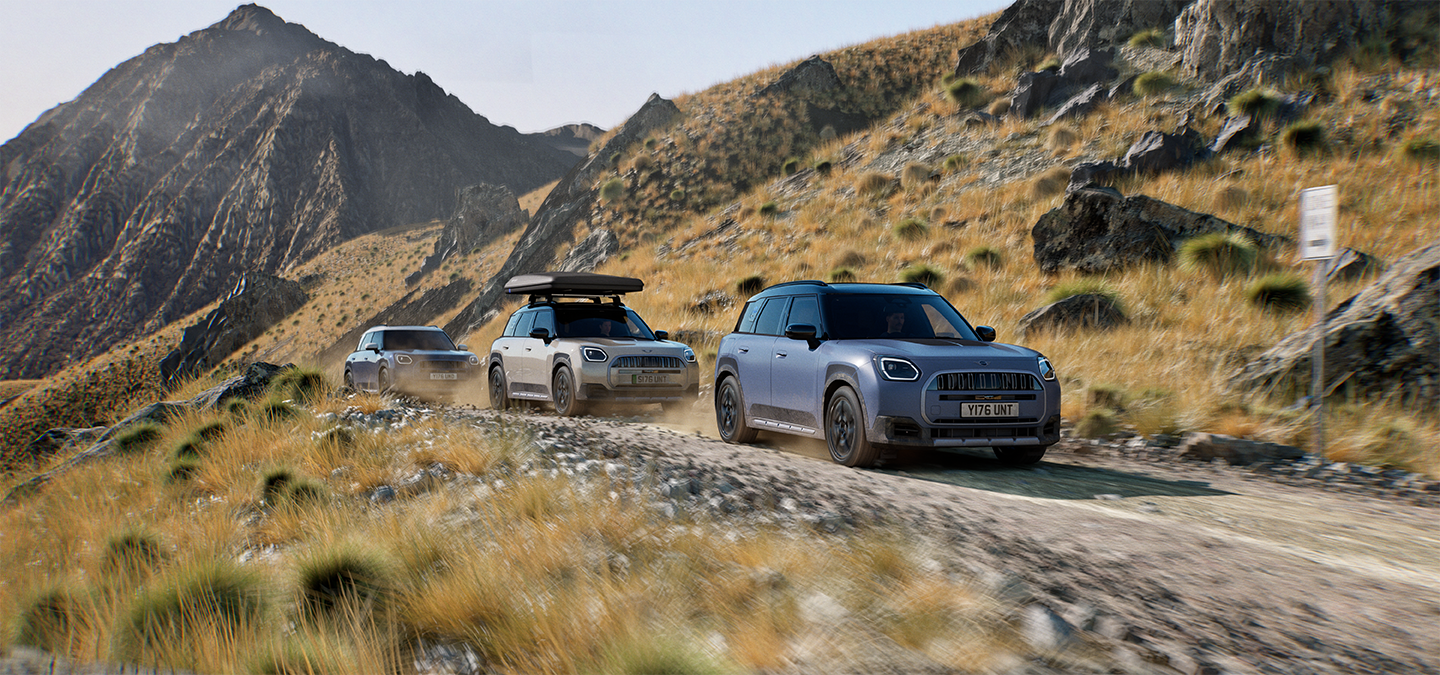 Image of multiple MINI Countryman Untamed Edition models driving offroad on a mountain road.