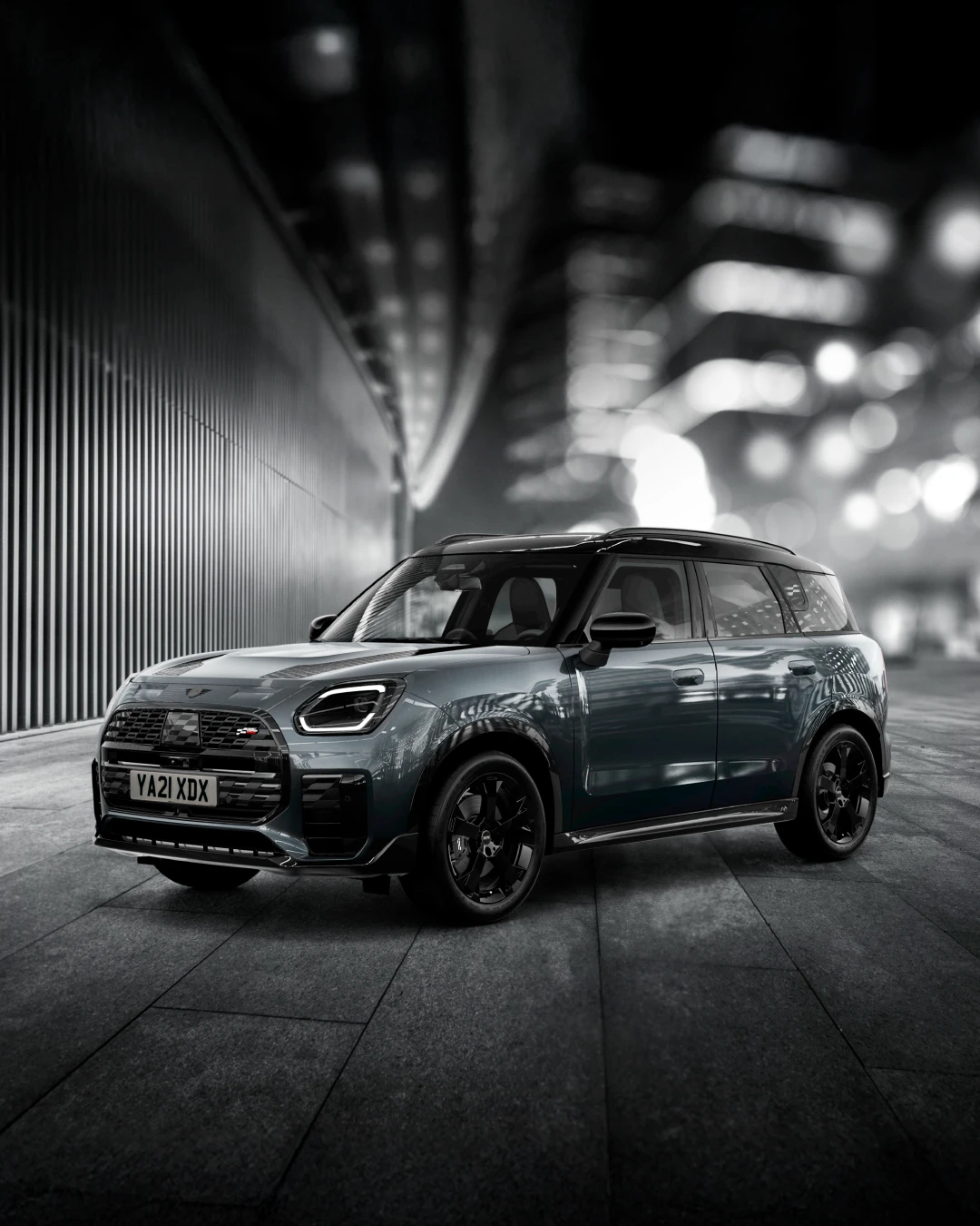 The MINI Countryman Shadow Edition gleams brightly on a nighttime street corner.
