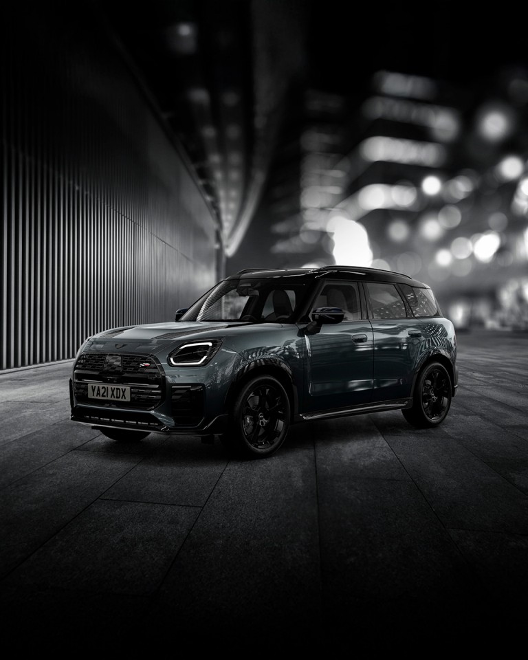The MINI Countryman Shadow Edition gleams brightly on a nighttime street corner.