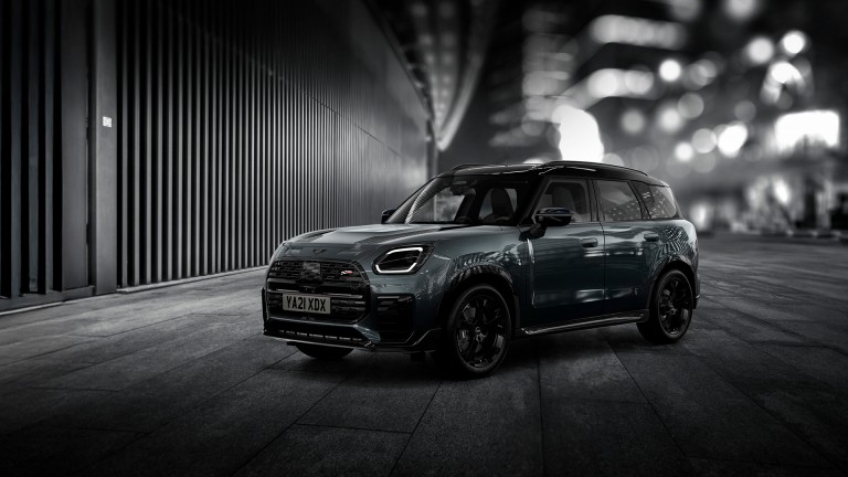The MINI Countryman Shadow Edition gleams brightly on a nighttime street corner.